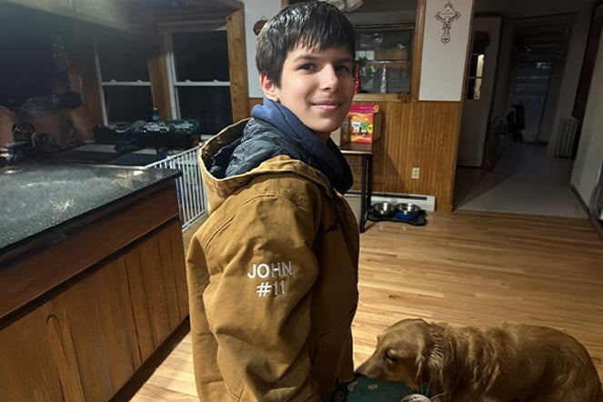 a child and a large dog in a kitchen