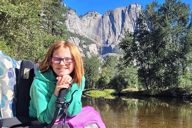 a child smiling near a river at Yosemite National Park
