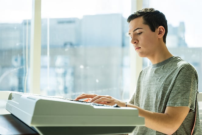 a teenager playing a keyboard