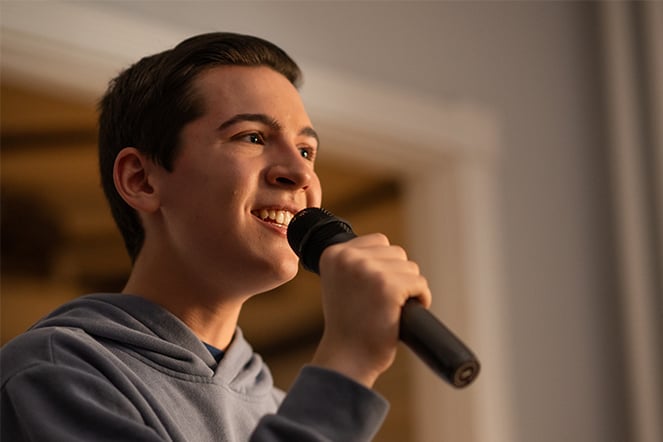 a teenager singing into a microphone