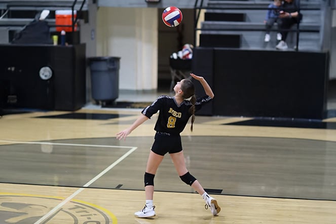 a volleyball player serving a ball