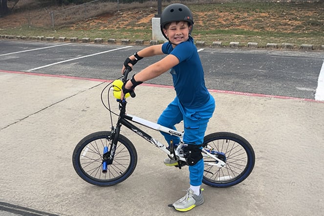 a child on a bike in a parking lot