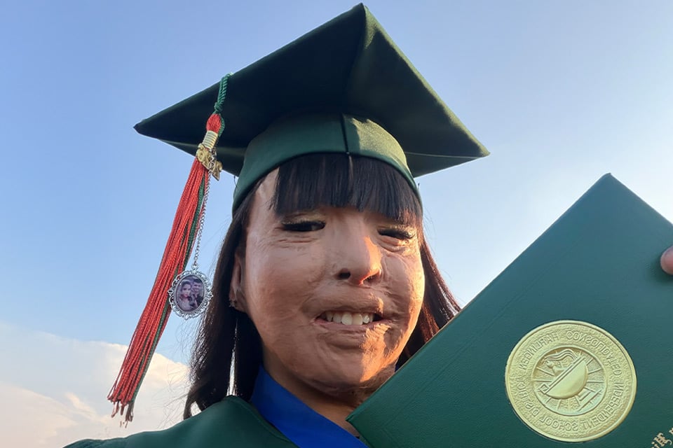 a child wearing a graduation cap holding a diploma