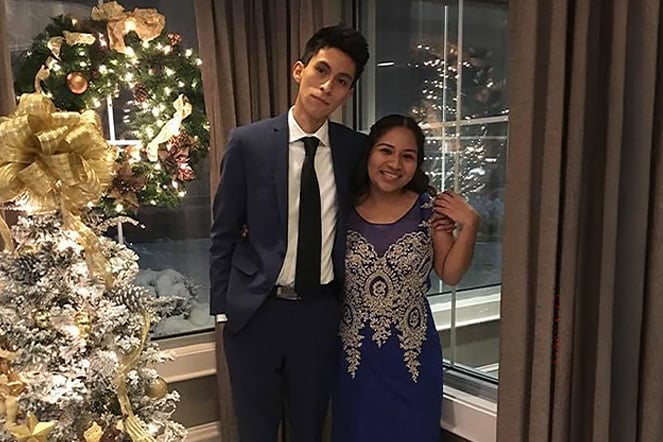 a man and a woman next to a Christmas tree