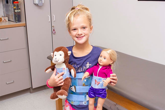a child holding two dolls