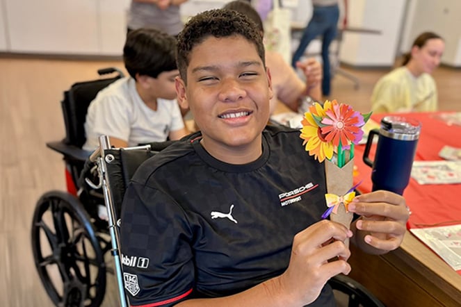 a child holds a bouquet of paper flowers