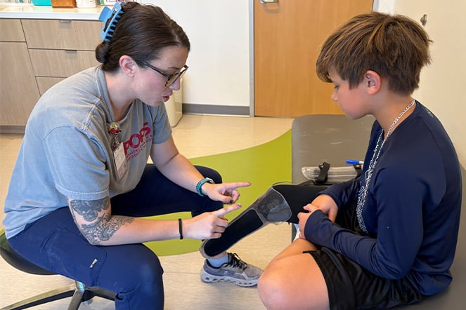 an adult makes adjustments to a prosthetic