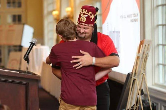 a man in a fez giving a hug