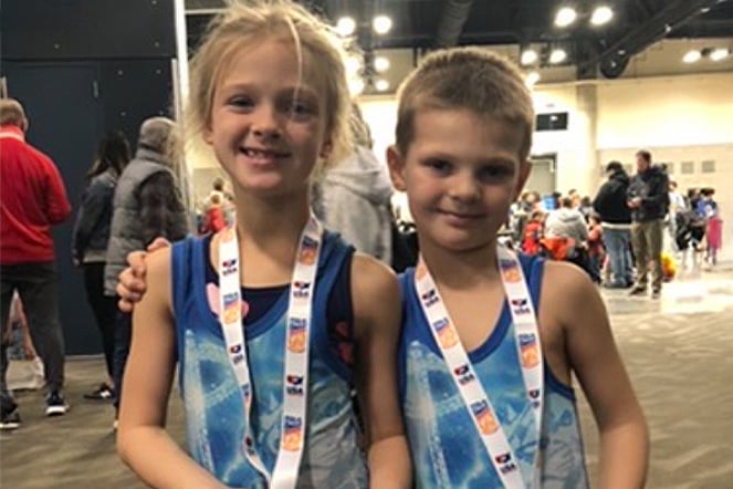 two child wrestlers wearing medals