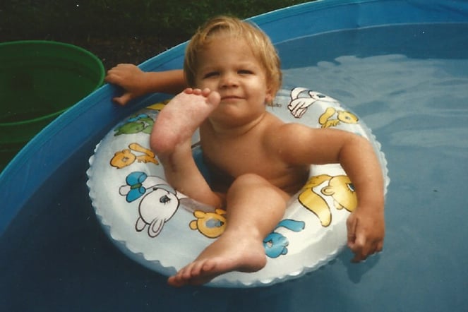 an aged photo of a child sitting in a pool float