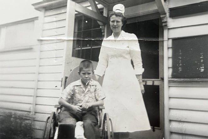 a vintage photo of a boy in a wheelchair next to a nurse