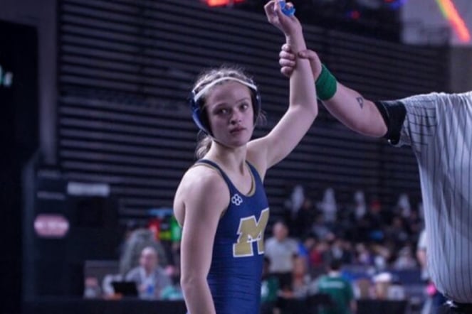 a youth wrestler having her arm raised