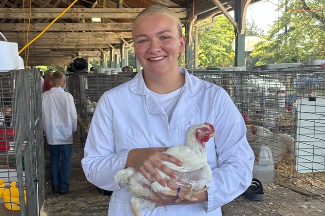 a teenager holding a chicken