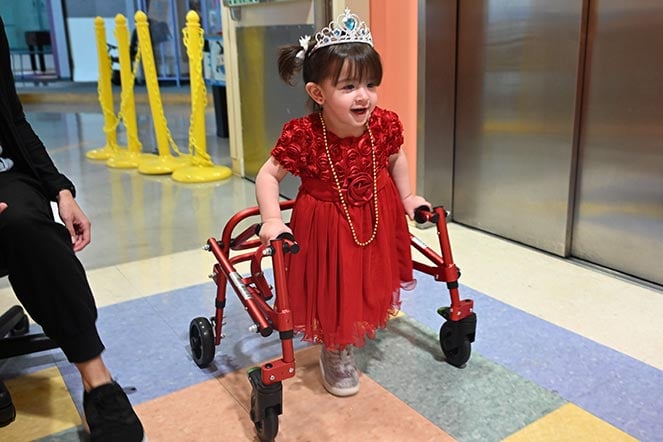 female child with cerebral palsy uses walker