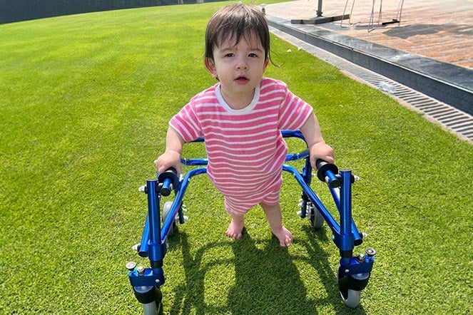 female child with cerebral palsy uses walker