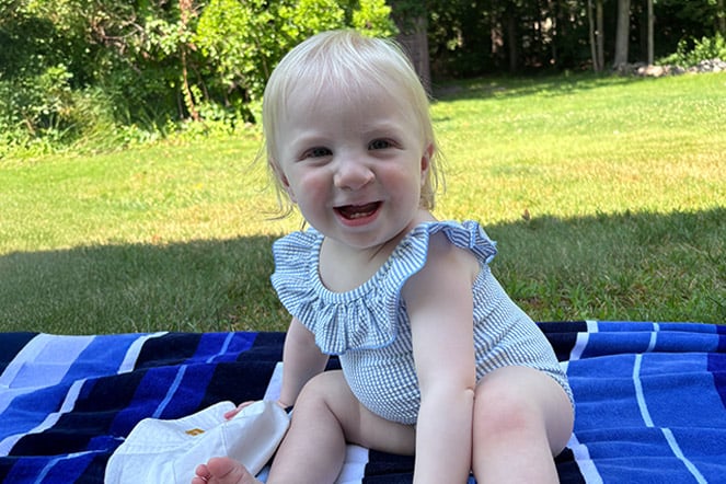 a smiling child on a blanket 
