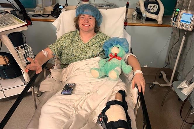 orthopedic patient in hospital bed wearing leg brace