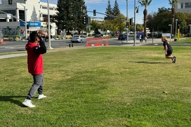 orthopedic patient and therapist play catch with football