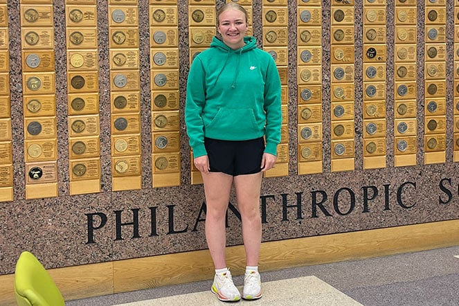 a child standing in front of a wall of awards