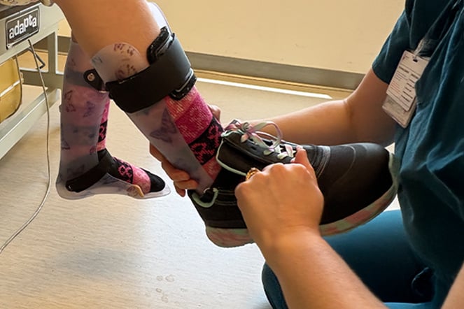 a child's leg brace being adjusted and fitted by an adult