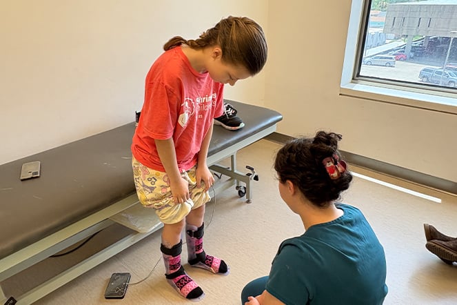 an adult inspects a child's leg braces
