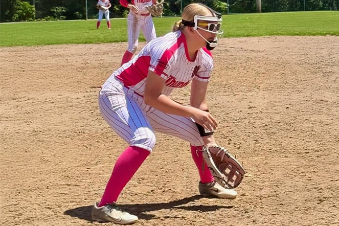 a softball player preparing to catch a ball