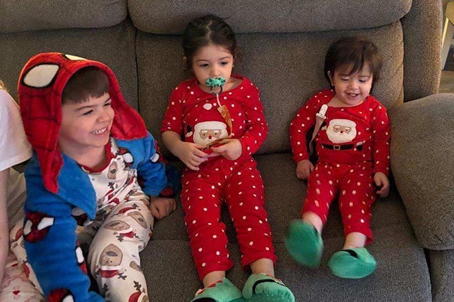 three young siblings sitting on sofa