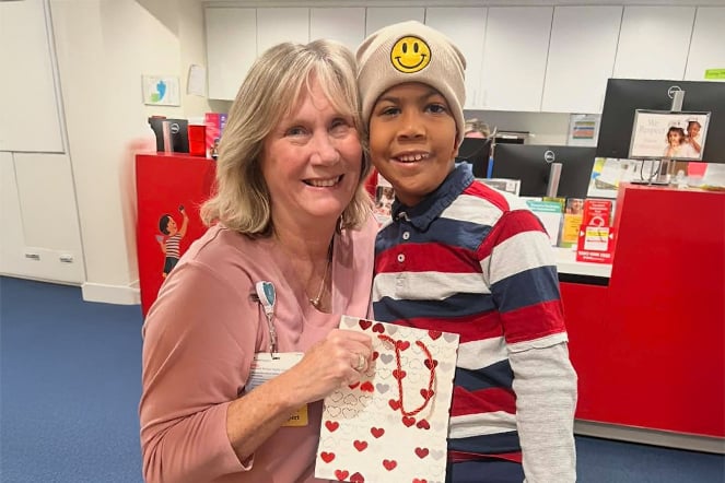 a woman holding a bag smiling with a child