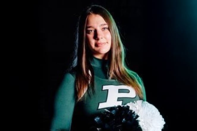 a portrait of a cheerleader in a uniform with a large "P" emblem and pom poms