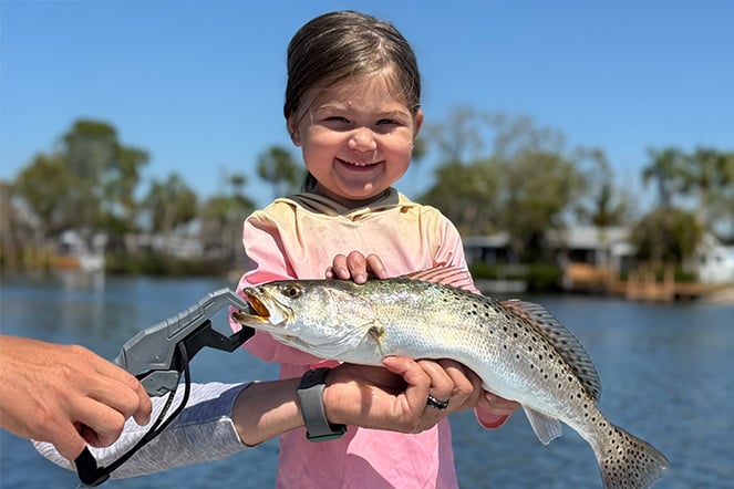 a young child on a boat holding a fish