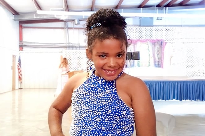 a portrait of a child in a pageant gown