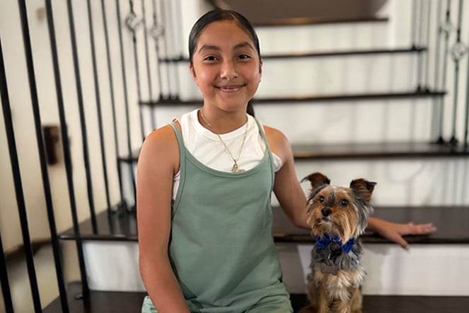 a child sitting on steps with a small dog