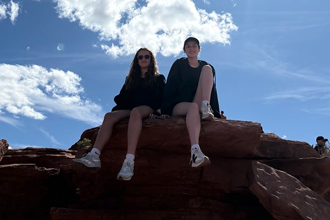 two children sitting on a boulder