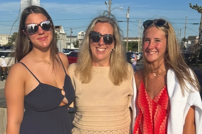 a mother standing with two twin daughters
