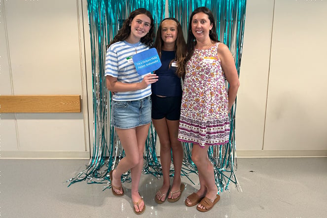 a mother and her two daughters in front of a photo background