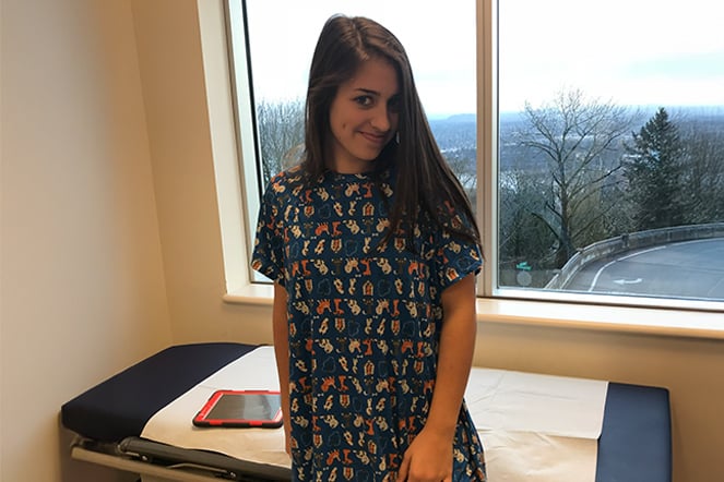 a child standing in front of a window in  a hospital room