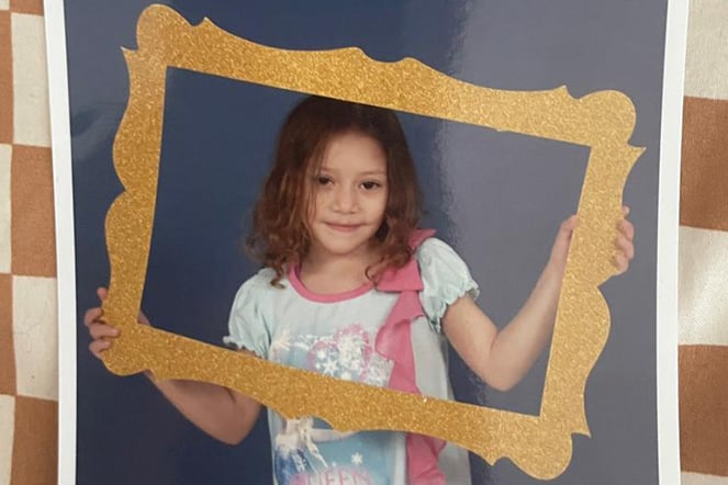 a child holding up an empty photo frame