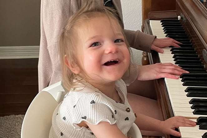 a child playing piano with an adult