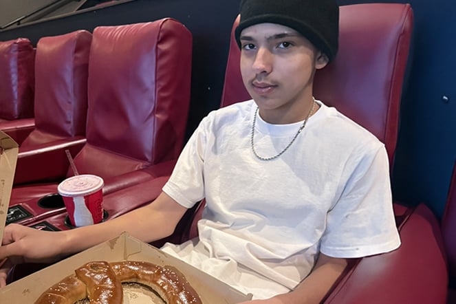 a child with a large pretzel in a movie theater