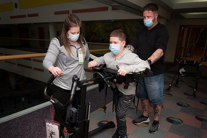 cerebral palsy patient during physical therapy, physical therapist, father