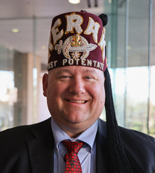 an adult man wearing a suit and a fez