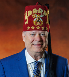 an adult man wearing a suit and a fez