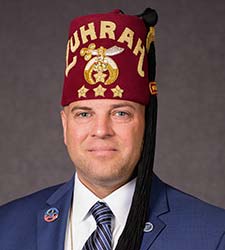 an adult man wearing a suit and a fez