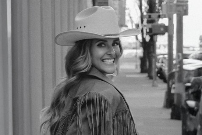a black and white photo of a woman in a cowboy hat