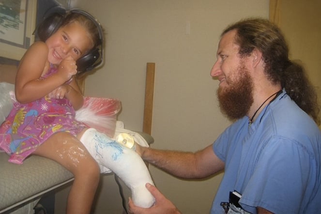 Aleia with Brock inspecting her prosthetic.