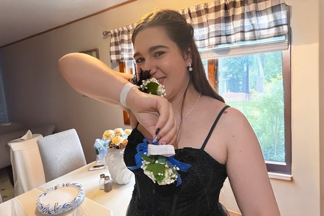 Aleia smelling the flowers in her prom corsage.