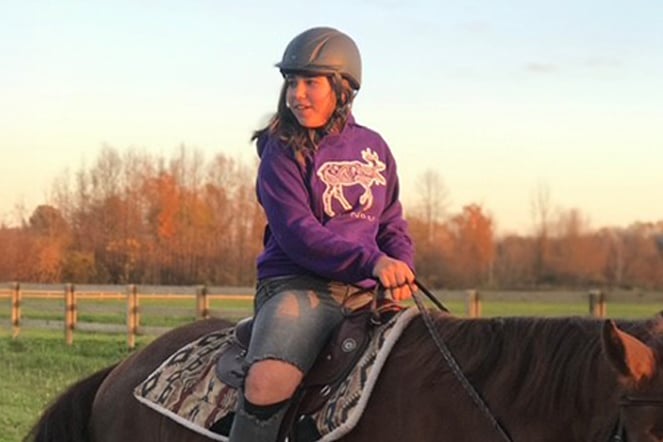 Aleia riding a horse.