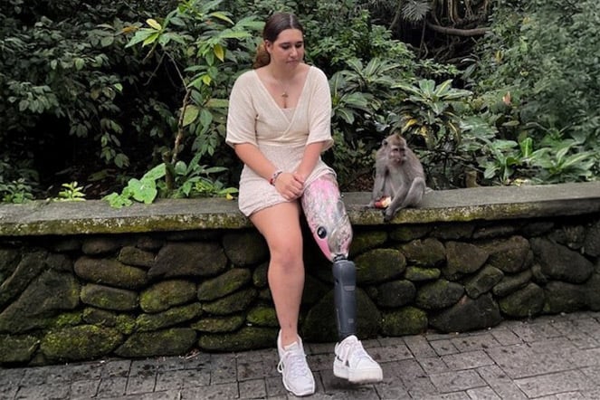  Aleia sitting next to a monkey in front of an array of plants.
