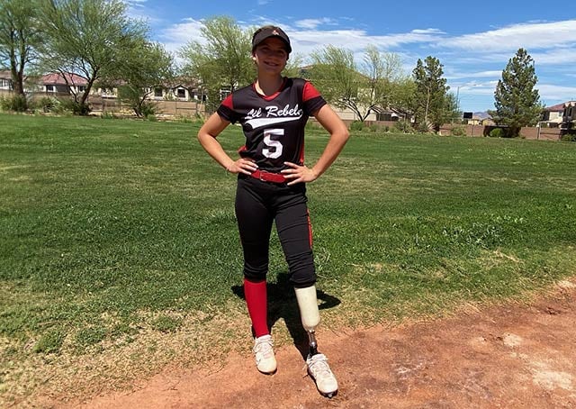 Ali smiles before a game while wearing softball uniform