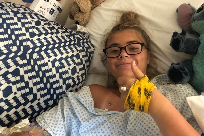 Allie gives thumbs up after spinal fusion surgery